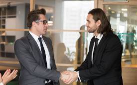 smiling-businessmen-shaking-hands-making-deal-merger-and-aquisition