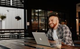 man-entrepreneur-sitted-laptop-on-table-happy-smiling