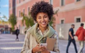 young-woman-student-holds-smartphone-outside-school-money-saving-app