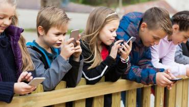 children-checking-their-smartphones-digital-advertisers-harvesting-kids-online-information-for-profits
