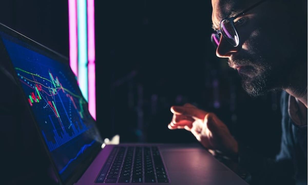 man analyzing stock crypto market charts financial data on laptop