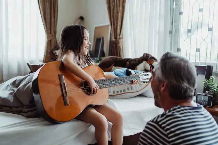 little-girl-with-guitar-on-bed