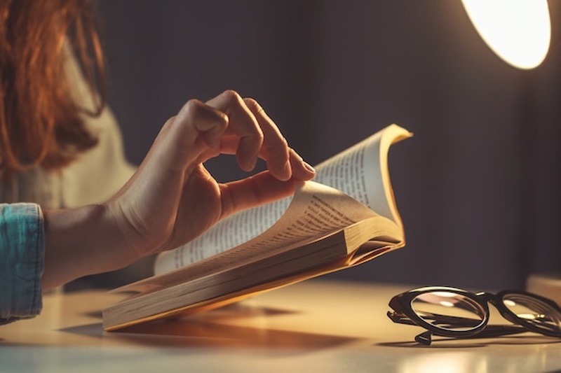 Woman reading book in the evening at home