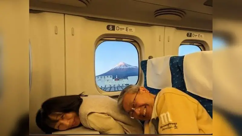 couple-goes-viral-for-ducking-to-let-passenger-take-pic-of-japans-mt-fuji
