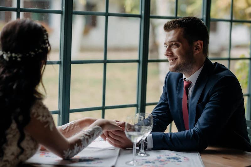 couple-happy-sitted-holding-hands-over-table-talking