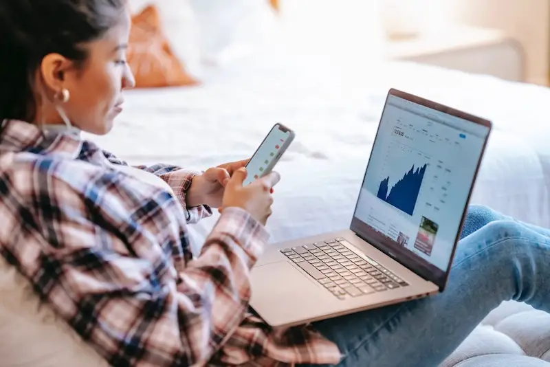 female-investor-using-smartphone-laptop
