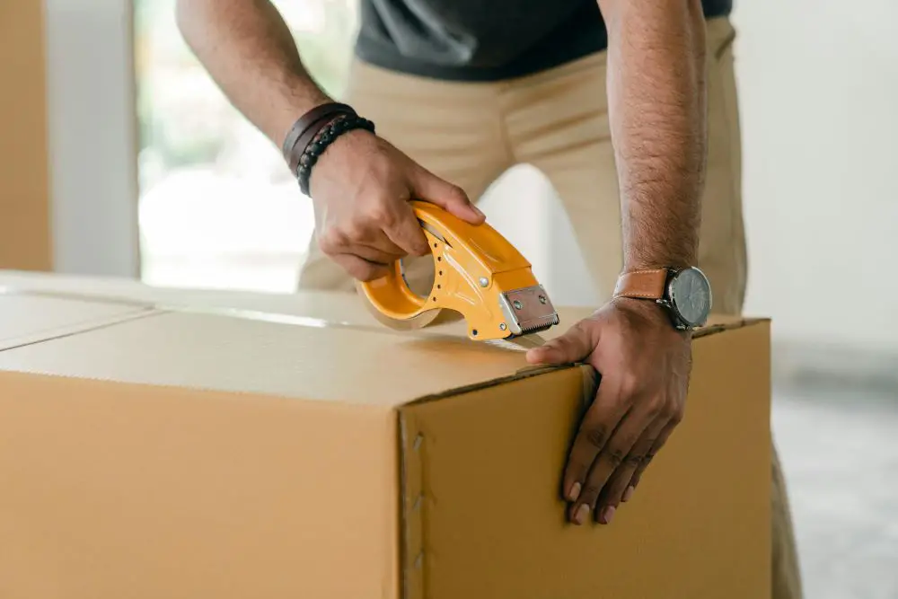 man packing a box while following storage regulations