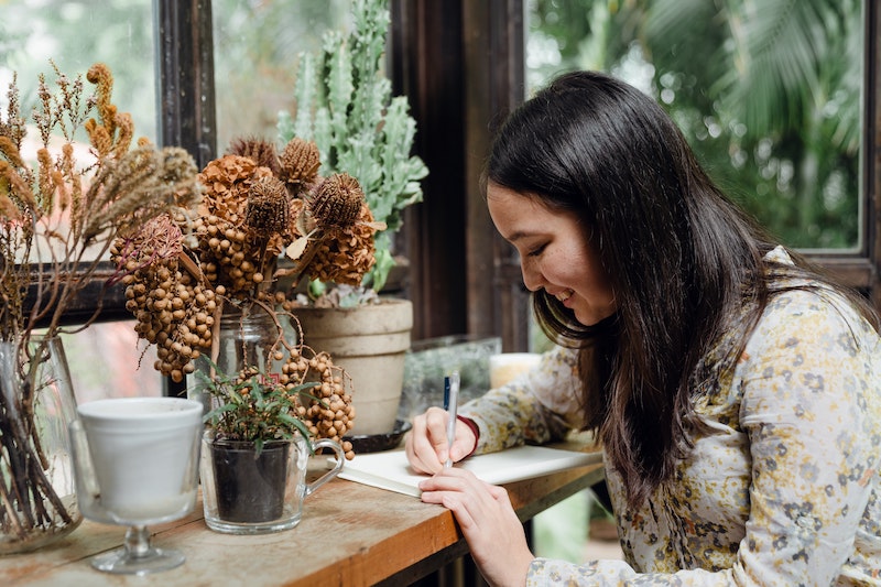 smiling-woman-writing-with-philosophical-concept-in-mind