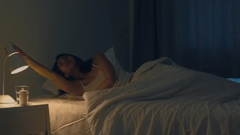 woman-in-bedroom-turning-off-lights-late-night-sleep-cozily