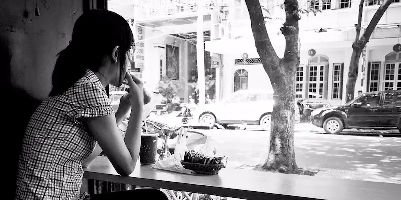 woman-sitting-at-cafe-looking-out