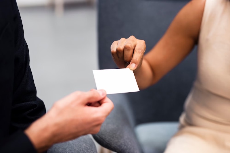 women-exchanging-business-card-sitted