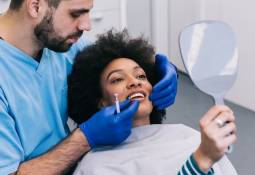 male-dentist-working-patient-young-woman-oral-care-cost
