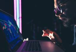 man analyzing stock crypto market charts financial data on laptop