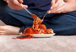 man-eating-food-on-plate-spilling-on-carpet
