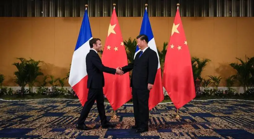 French President Emmanuel Macron shakes hands with Chinese President Xi Jinping