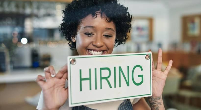 businesswoman-owner-smiling-hiring-sign