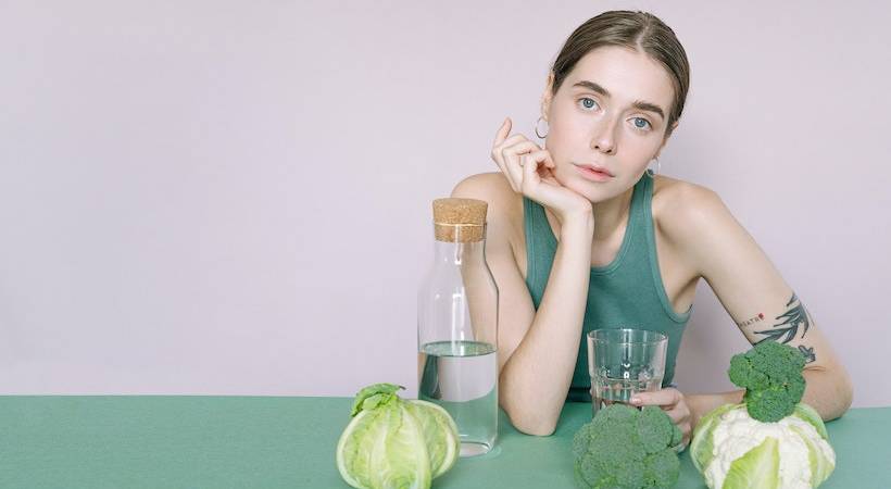 female-vegan-dietary-supplements-vegies-water-on-table