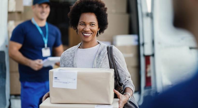 happy-african-american-woman-holding-delivered-packages-couriers-is-standing-background