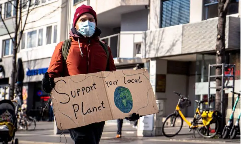 man-protester-carrying-protet-planet-sign
