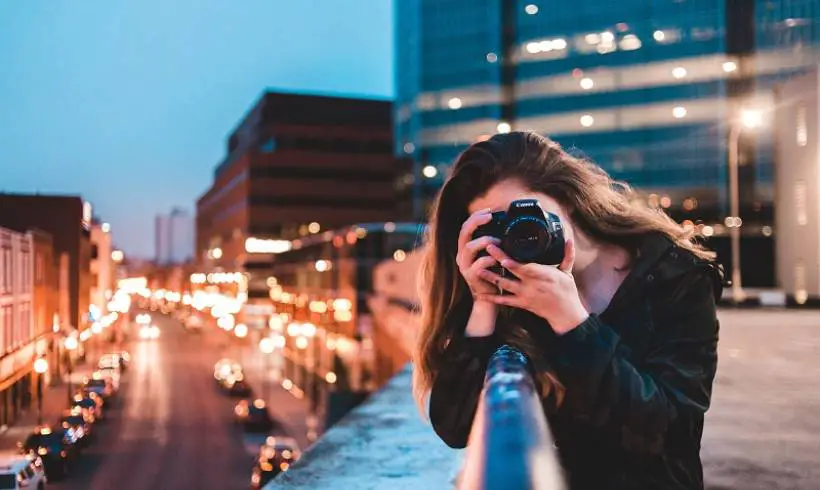 young-woman-using-camera-photography-city-improve-writing