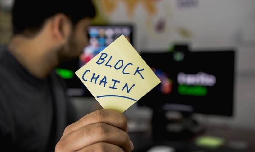 man_holding_card_blockchain_benefits