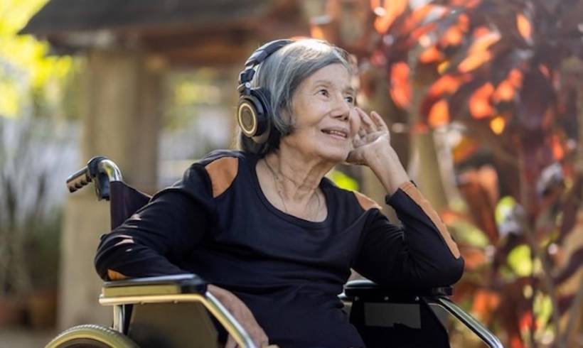 senior_woman_asian_listening_music_with_headphone_in_backyard