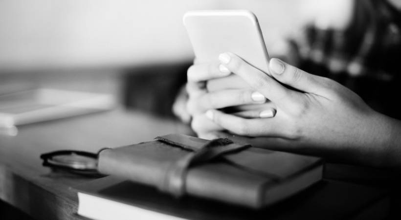 woman-using-cellphone-bible-on-table