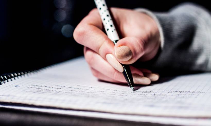 female-hand-holding-pen-writing-longhand