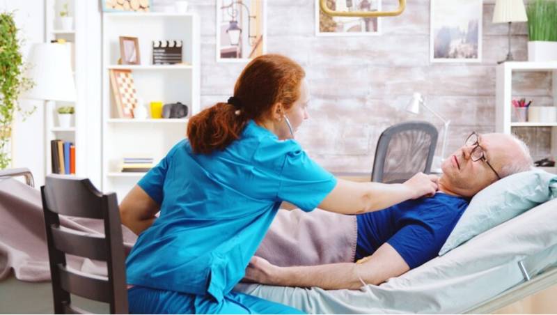 Critical_Care_Nurse_Working_with_Elderly_Man_Patien_in_Bed