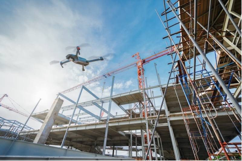 Drone flying over construction site for surveillance or industrial inspection