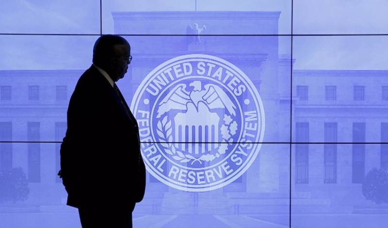 Security guard walks by an image of the Federal Reserve