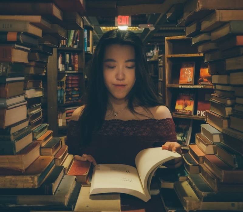 Lady Reading a Book in a Library