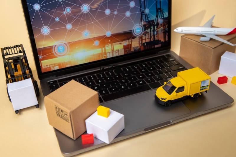 Vehicles on laptop supply chain management representation.