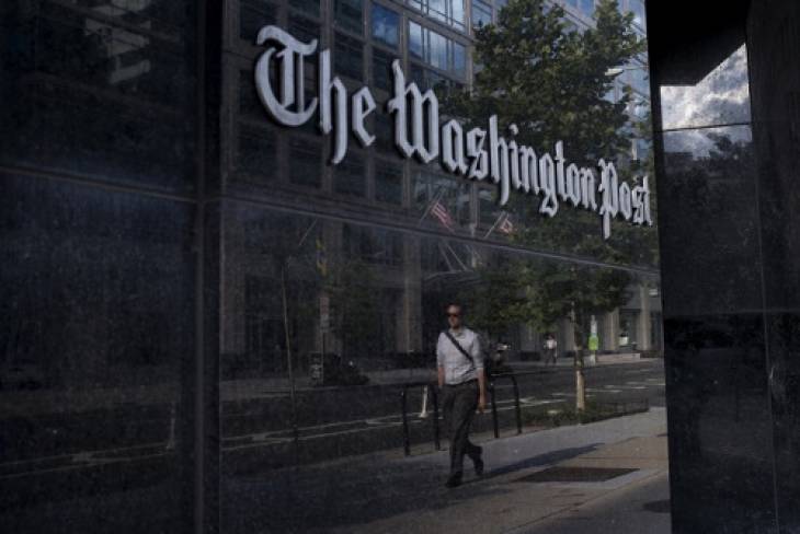 man_walks_past_washington_post_office_building_in_washington_dc