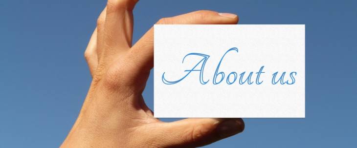 hand-holding-up-card-written-about-us-sky-background