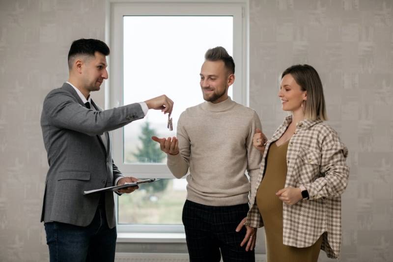 agent-handing-couple-house-keys-home-purchase