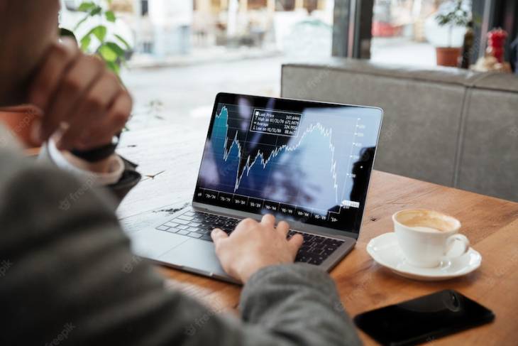 businessman-sitting-by-table-analyzing-stock-indicators