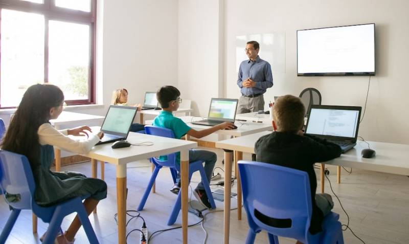 classroom-teacher-explaining-lesson-pupils-pros-cons-of-AI-in-education