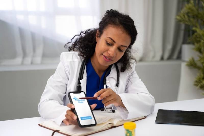 female-doctor-holding-smartphone-showing-medial-app