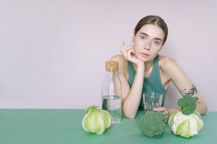 female-vegan-dietary-supplements-vegies-water-on-table