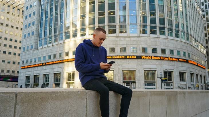 man-using-smartphone-near-buildings-fintech-repalce-banks