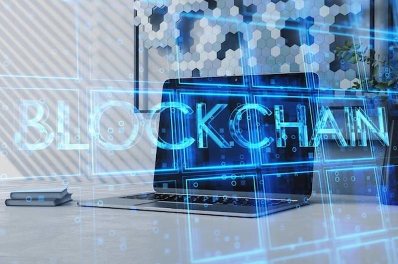 laptop-on-desk-with-creative-blue-cubes-blockchain-text