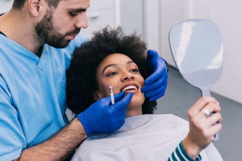 The Evolving Costs of Dental Care in the 2020s: What Is Driving Costs Up? male-dentist-working-patient-young-woman-oral-care-cost
