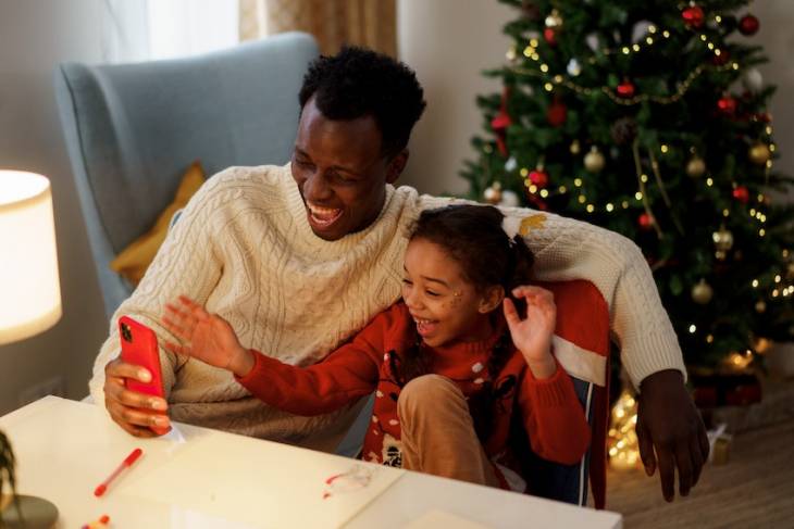 man-daughter-christmas-watching-tv-on-smartphone-memorable-christmas-tv-specials