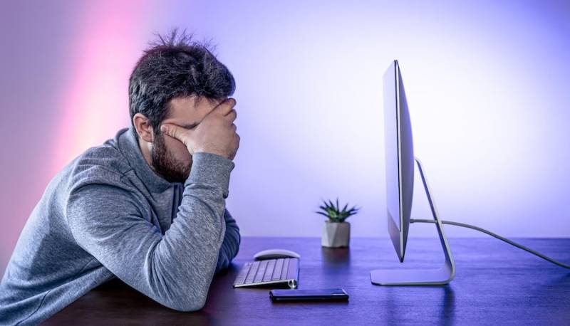 man-in-front-computer-covering-his-face-with-his-hands-zombieload-hacker-attack