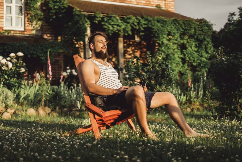 man-resting-country-house-sunset-green-lawn-staycation