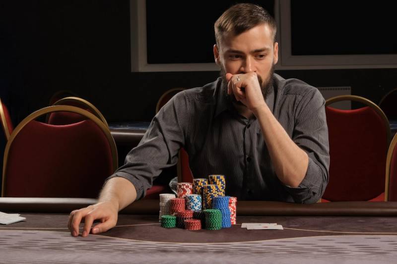 How to Spot Early Signs You're on a Path to Excessive Gambling man-thinking-gambling-chips-on-table