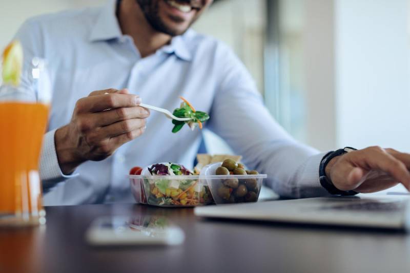 man-using-laptop-during-lunch-break-eating-food-combinations