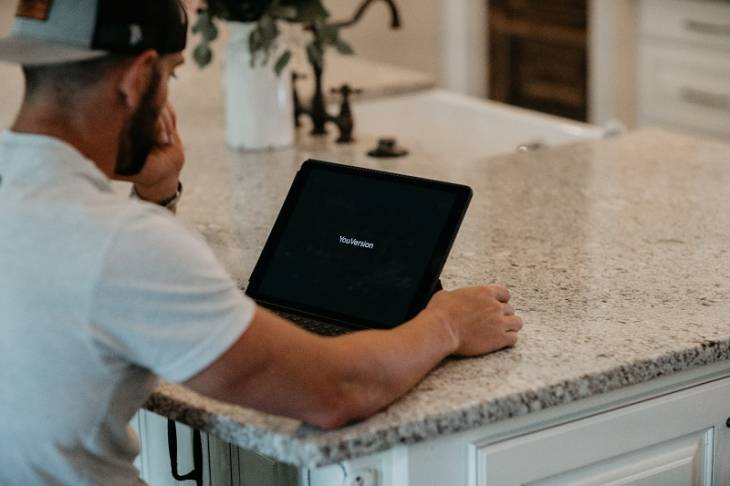 man_wearing_cap_using_laptop_build_online_presence_with_website_builders