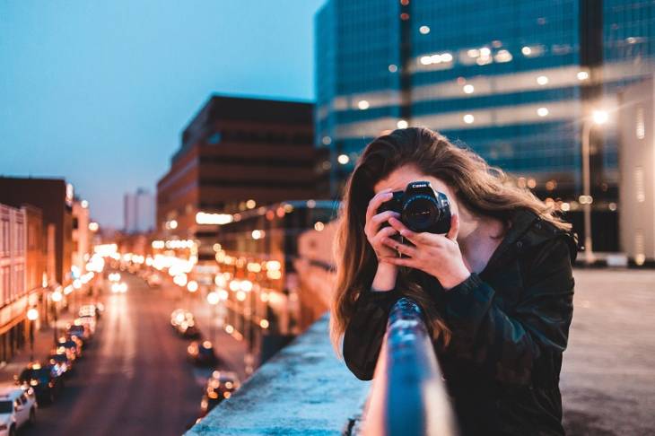 young-woman-using-camera-photography-city-improve-writing